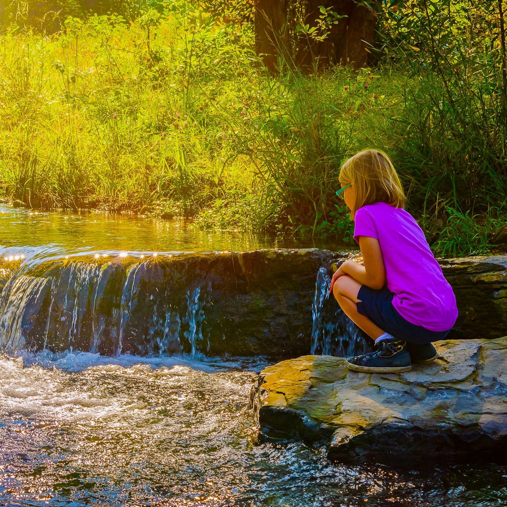 Young girl plays in Towne Branch Stream Restoration at Depot Park.
